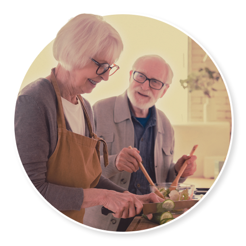 An older couple in their kitchen looking at something together